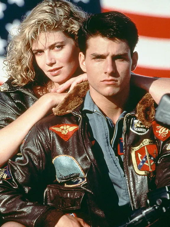 Tom Cruise ao lado de Kelly McGillis vestindo sua icônica jaqueta top gun